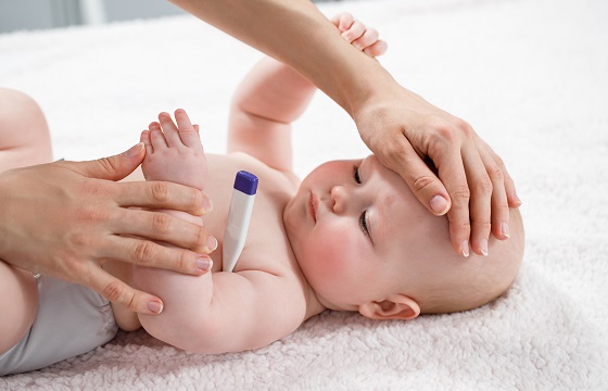 Ein Baby mit Fieberthermometer